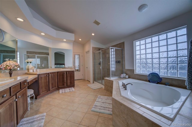 bathroom with tile patterned flooring, vanity, vaulted ceiling, and plus walk in shower