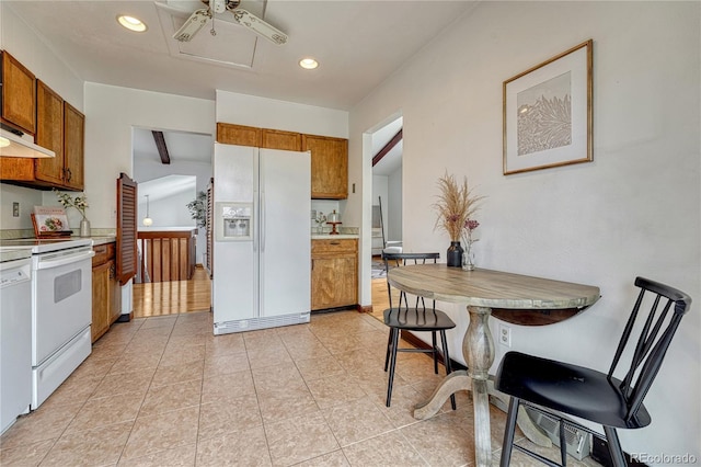 kitchen with white appliances, brown cabinetry, light countertops, recessed lighting, and light tile patterned floors