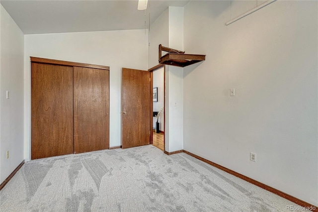 unfurnished bedroom featuring carpet flooring, baseboards, a closet, and ceiling fan