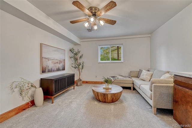 carpeted living room featuring ceiling fan and baseboards