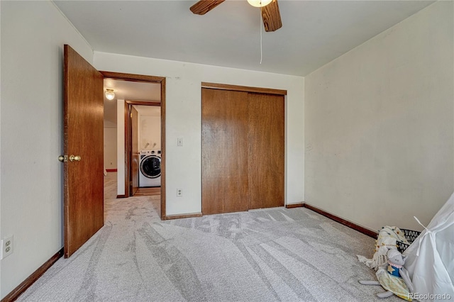 bedroom with washer / dryer, light carpet, baseboards, a closet, and a ceiling fan