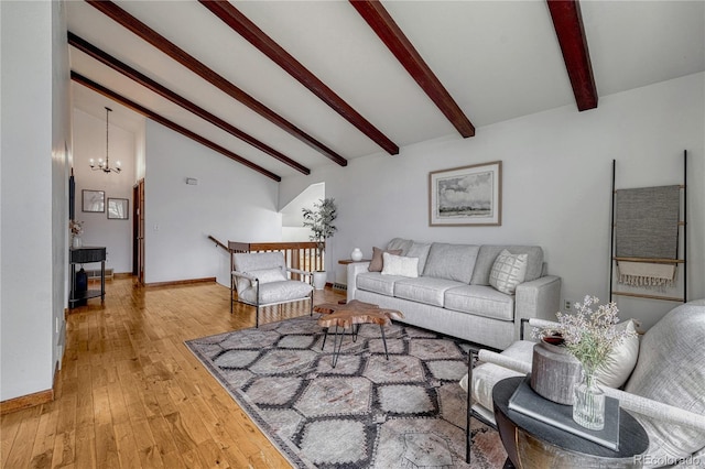 living area featuring a chandelier, hardwood / wood-style flooring, and baseboards