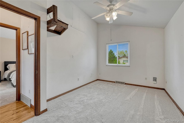 carpeted spare room featuring ceiling fan, baseboards, and lofted ceiling