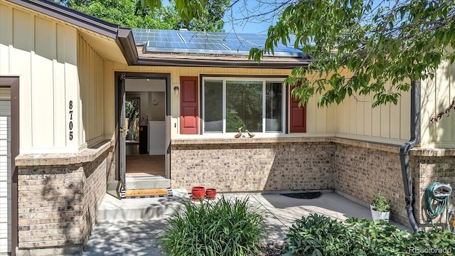 8705 W 86th Dr, Arvada, CO 80005 - entrance to property featuring roof mounted solar panels and brick siding