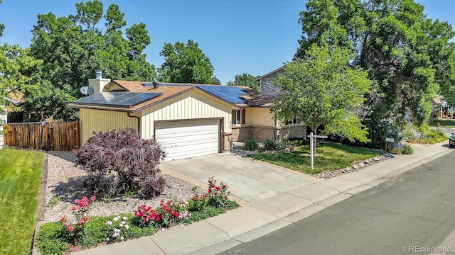 8705 W 86th Dr, Arvada, CO 80005 - view of front of property featuring an attached garage, solar panels, and concrete driveway