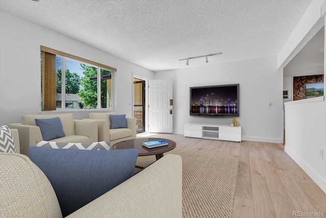 8705 W 86th Dr, Arvada, CO 80005 - living room with wood finished floors, rail lighting, and a textured ceiling