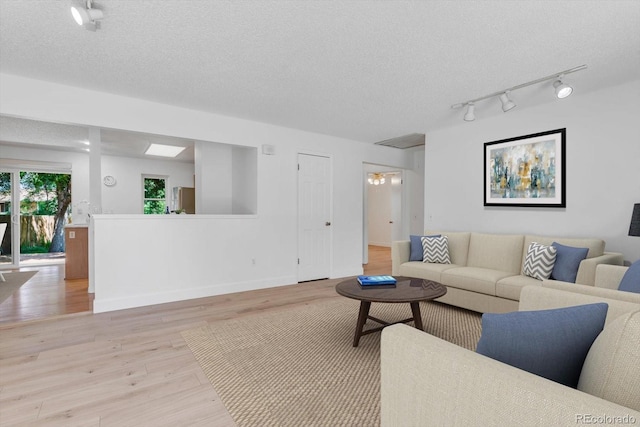 8705 W 86th Dr, Arvada, CO 80005 - living room with track lighting, light wood finished floors, and a textured ceiling