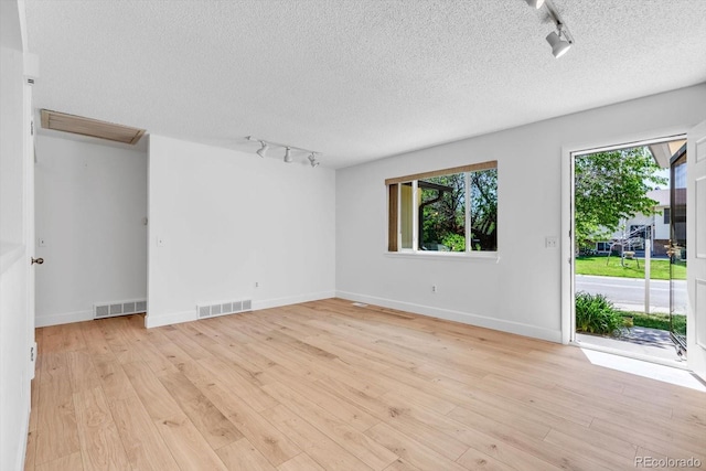 8705 W 86th Dr, Arvada, CO 80005 - empty room featuring track lighting, a textured ceiling, and light wood finished floors