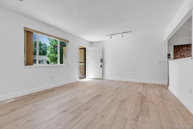 8705 W 86th Dr, Arvada, CO 80005 - spare room with a textured ceiling, light wood-style floors, and track lighting