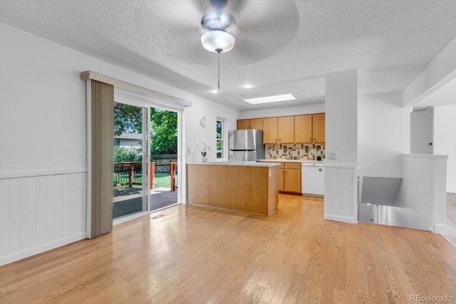 8705 W 86th Dr, Arvada, CO 80005 - kitchen with freestanding refrigerator, dishwasher, light countertops, a textured ceiling, and light wood finished floors