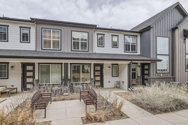 townhome / multi-family property with a porch, board and batten siding, and a shingled roof