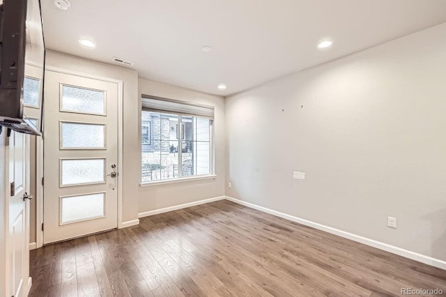 interior space with hardwood / wood-style flooring, recessed lighting, visible vents, and baseboards