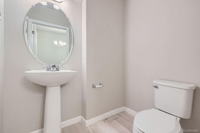 bathroom with baseboards, toilet, and wood finished floors