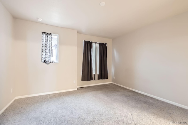 carpeted empty room with visible vents and baseboards