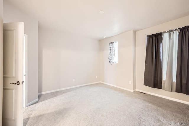 unfurnished room with carpet floors and baseboards