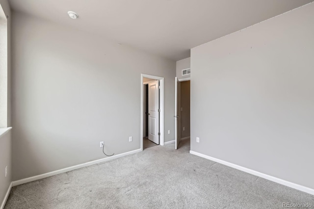 carpeted empty room featuring visible vents and baseboards