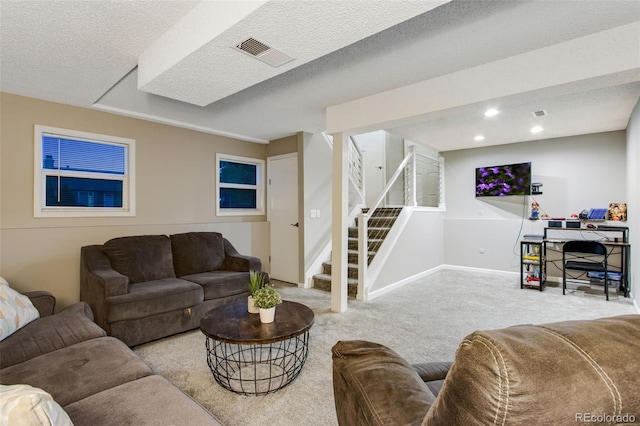 living room with a textured ceiling and light colored carpet