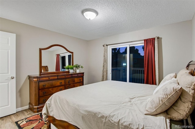 bedroom with light hardwood / wood-style floors, access to outside, and a textured ceiling