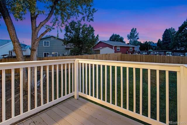 deck at dusk featuring a yard