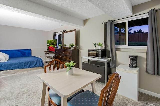 carpeted dining room with a textured ceiling