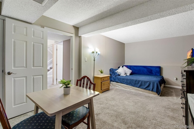 bedroom featuring a textured ceiling and light colored carpet