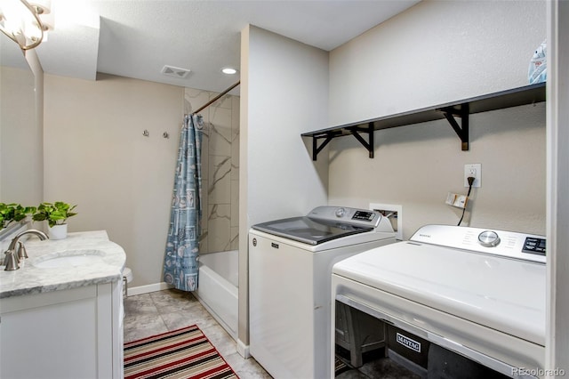 washroom featuring light tile patterned flooring, sink, and separate washer and dryer