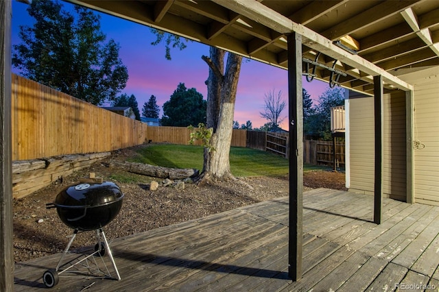 deck at dusk with a lawn and a grill