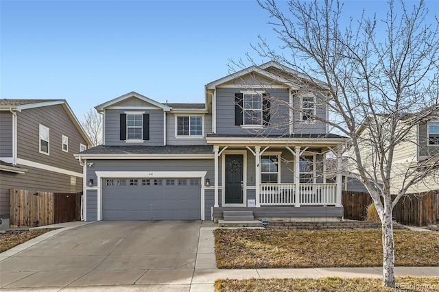 traditional-style house featuring a garage, concrete driveway, covered porch, and fence