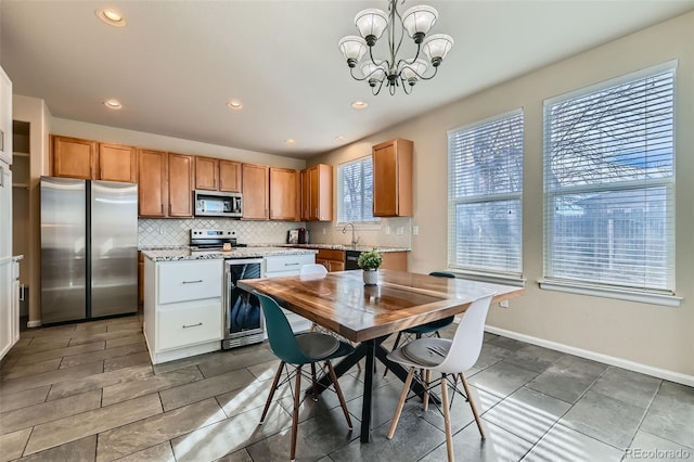 kitchen with pendant lighting, stainless steel appliances, decorative backsplash, and a center island