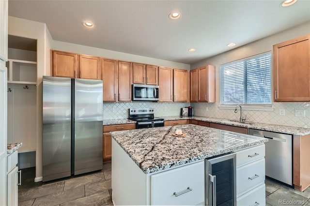 kitchen with wine cooler, appliances with stainless steel finishes, a center island, a sink, and backsplash