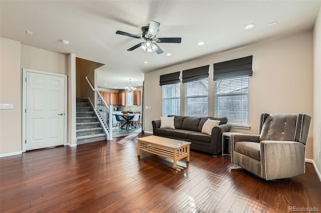 living room featuring baseboards, dark wood finished floors, stairs, ceiling fan with notable chandelier, and recessed lighting