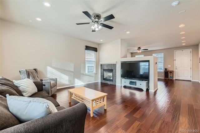 living area with baseboards, a ceiling fan, a tile fireplace, dark wood-style floors, and recessed lighting