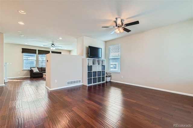 living room with dark wood-style floors, baseboards, visible vents, and recessed lighting