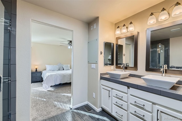 bathroom featuring visible vents, a sink, ensuite bath, and ceiling fan