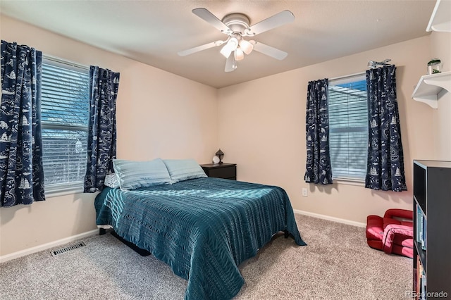 carpeted bedroom with a ceiling fan, visible vents, and baseboards