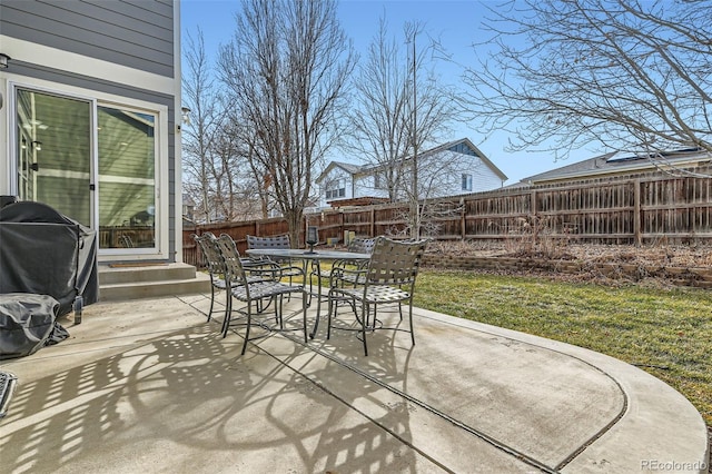 view of patio with entry steps, outdoor dining area, a fenced backyard, and grilling area