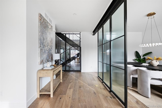 hall with stairs, hardwood / wood-style floors, and floor to ceiling windows