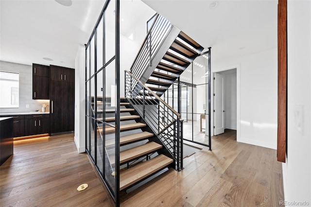 stairway with hardwood / wood-style floors and baseboards