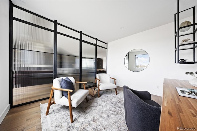 living area featuring baseboards and wood finished floors