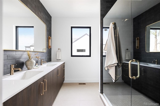 bathroom with a sink, tasteful backsplash, a shower stall, and tile patterned floors