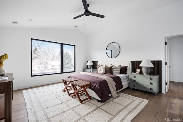 bedroom featuring baseboards, lofted ceiling, wood finished floors, and a ceiling fan