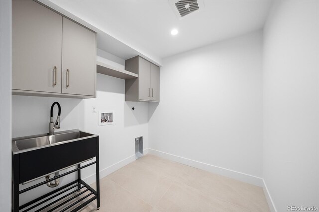 washroom with hookup for a washing machine, baseboards, hookup for an electric dryer, cabinet space, and a sink