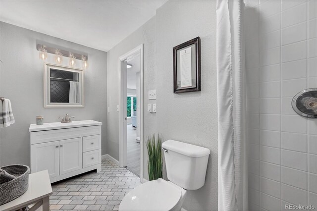 9053 Clydesdale Rd, Castle Rock, CO 80108 - bathroom featuring vanity, tiled shower, toilet, and tile patterned floors