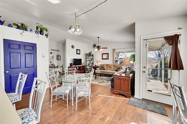 dining area with a ceiling fan, light wood-type flooring, and lofted ceiling