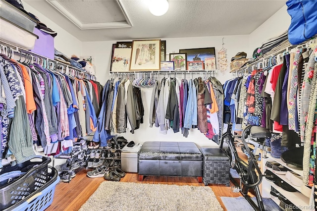 spacious closet with wood finished floors and attic access