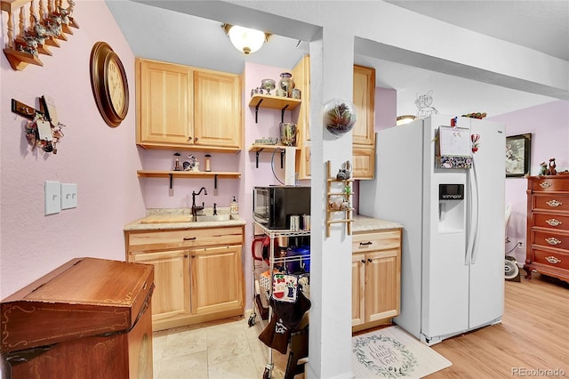 kitchen featuring white fridge with ice dispenser, light brown cabinets, black microwave, open shelves, and a sink