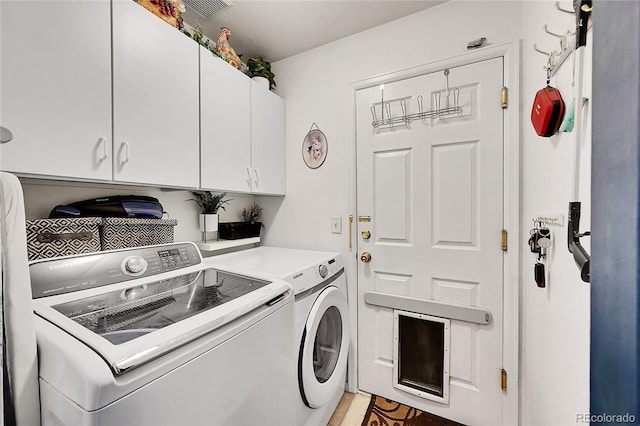 laundry area featuring visible vents, independent washer and dryer, and cabinet space