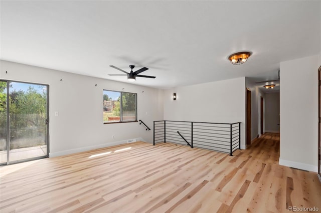 unfurnished room with baseboards, ceiling fan, and light wood finished floors