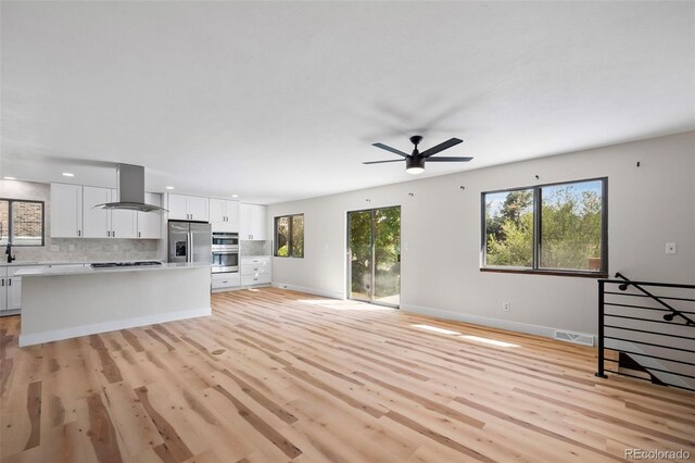 unfurnished living room featuring light hardwood / wood-style flooring and ceiling fan