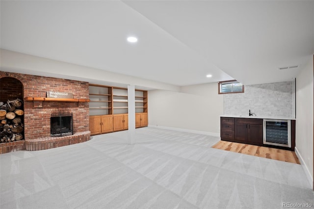 living room with light wood-type flooring, a brick fireplace, wet bar, and wine cooler